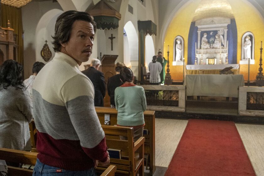 Actor Mark Wahlberg stands in a Catholic church in a scene in “Father Stu.”