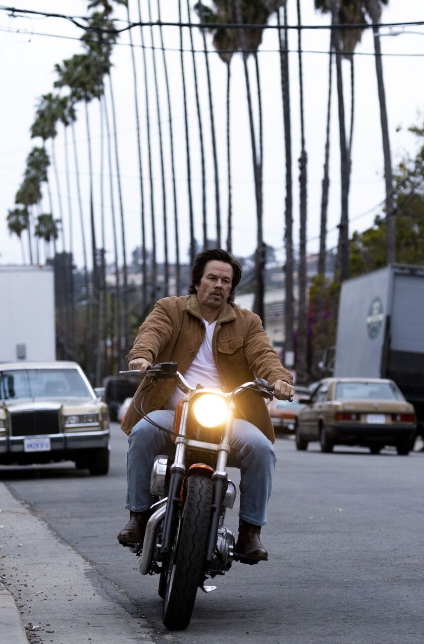 Mark Wahlberg rides a motorcycle in “Father Stu.”