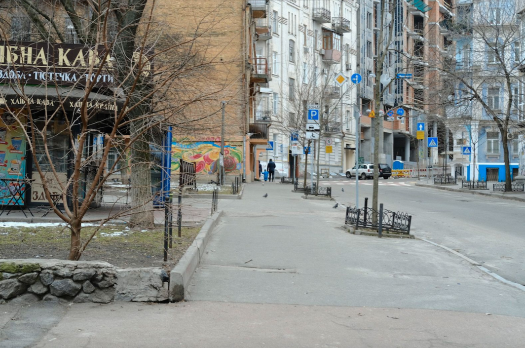 On an otherwise empty street, a family takes a walk just before curfew.