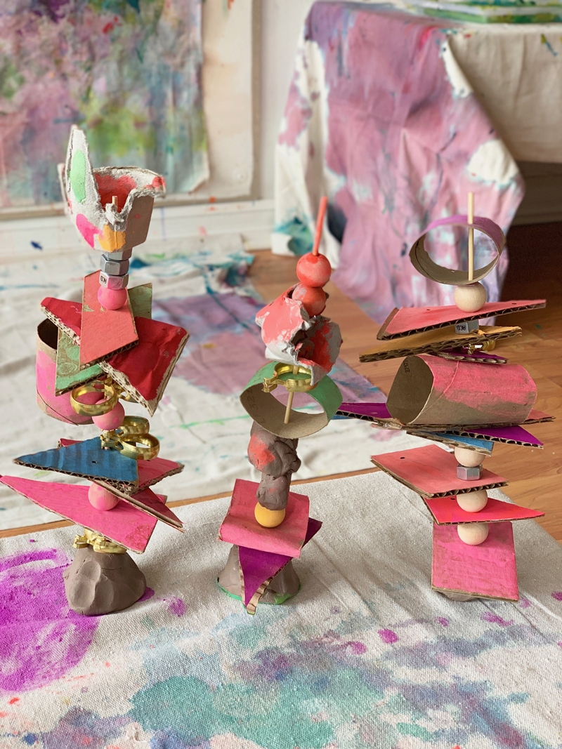 Kids make stacked sculptures using clay, a wooden skewer, beads, and recylables.