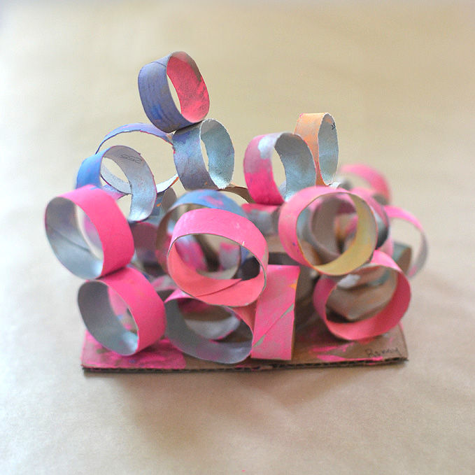 Kids make sculptures from toilet paper rolls.